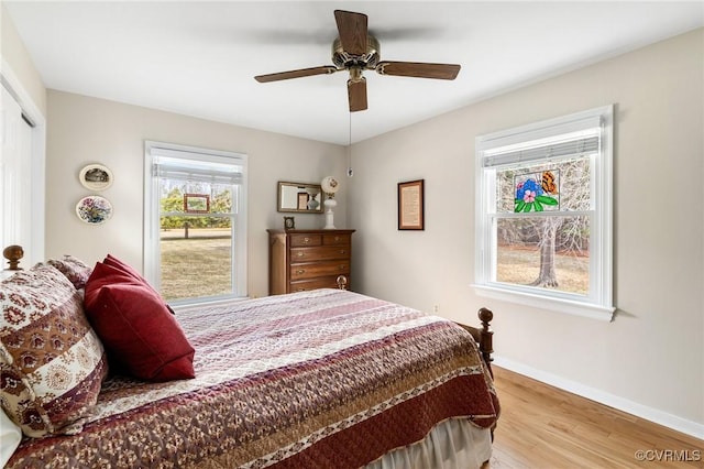 bedroom featuring a closet, ceiling fan, baseboards, and wood finished floors