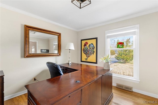 home office with light wood-style floors, visible vents, ornamental molding, and baseboards