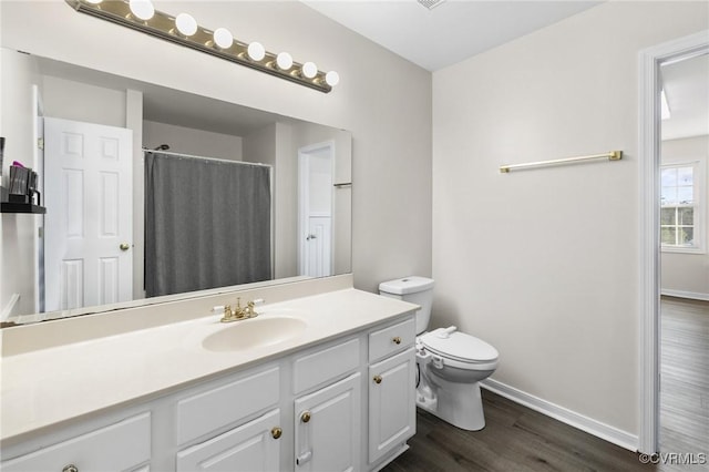 full bath featuring vanity, wood finished floors, toilet, and baseboards