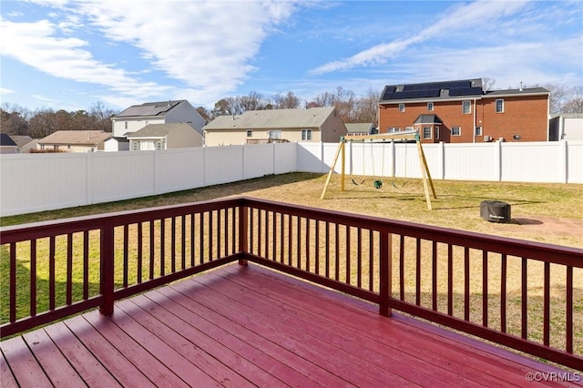 wooden terrace with a fenced backyard, a residential view, a playground, and a yard