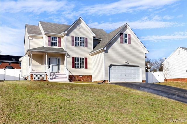 traditional-style home featuring aphalt driveway, a garage, fence, a gate, and a front lawn