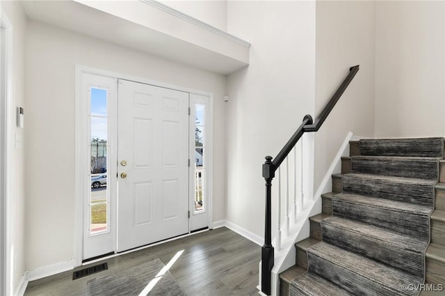 entrance foyer featuring stairs, wood finished floors, visible vents, and baseboards