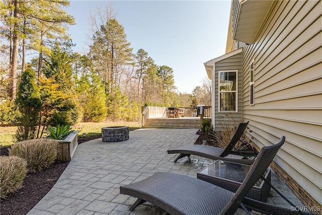 view of patio / terrace featuring an outdoor fire pit and a deck