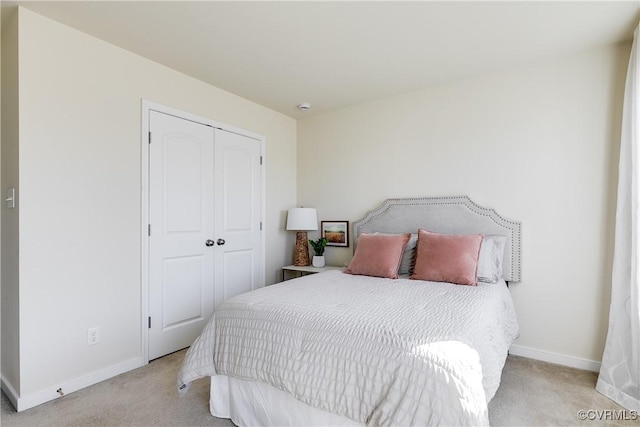 carpeted bedroom with baseboards and a closet