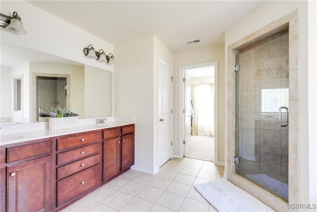 bathroom with double vanity, a stall shower, visible vents, tile patterned floors, and a sink