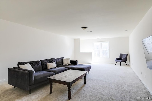 living area featuring light carpet and baseboards