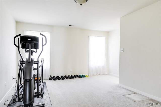 exercise room with carpet, visible vents, and baseboards