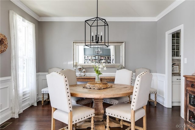 dining area with visible vents, wainscoting, dark wood-type flooring, crown molding, and a notable chandelier