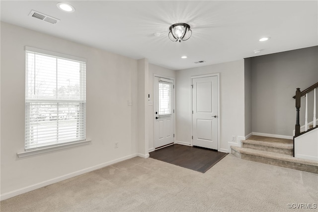 foyer entrance featuring stairs, visible vents, dark colored carpet, and recessed lighting