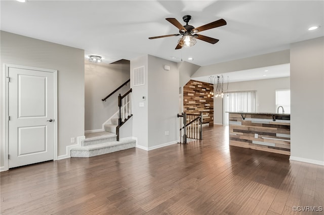 spare room featuring baseboards, stairs, visible vents, and wood finished floors