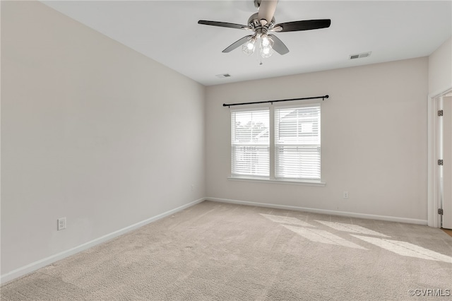 empty room featuring light carpet, visible vents, and baseboards