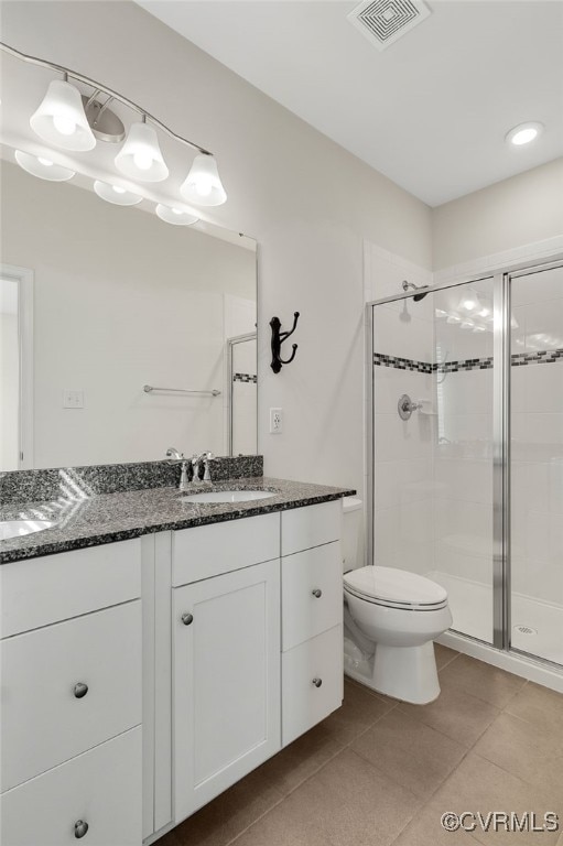 full bath with double vanity, visible vents, toilet, a shower stall, and a sink