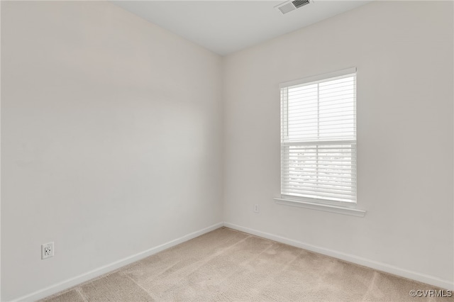 empty room featuring light carpet, baseboards, and visible vents