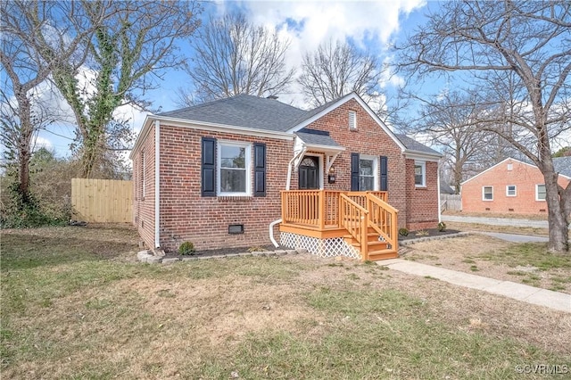 bungalow-style house featuring brick siding, fence, crawl space, roof with shingles, and a front lawn