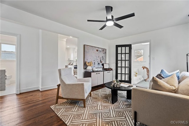 living room with ceiling fan, dark wood-style flooring, and baseboards