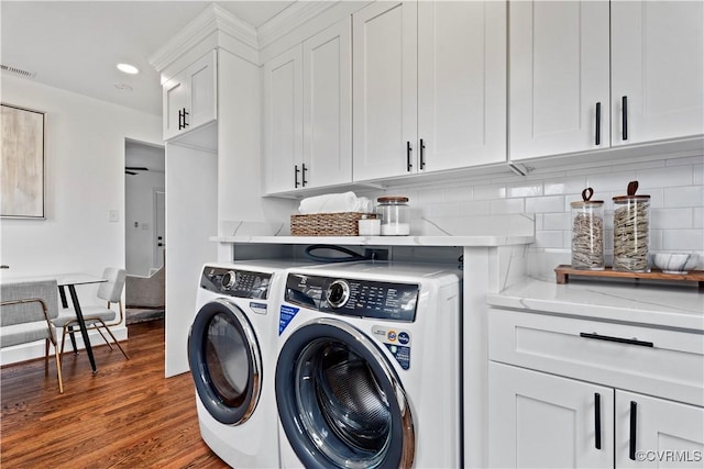 laundry room featuring recessed lighting, wood finished floors, visible vents, washer and dryer, and cabinet space