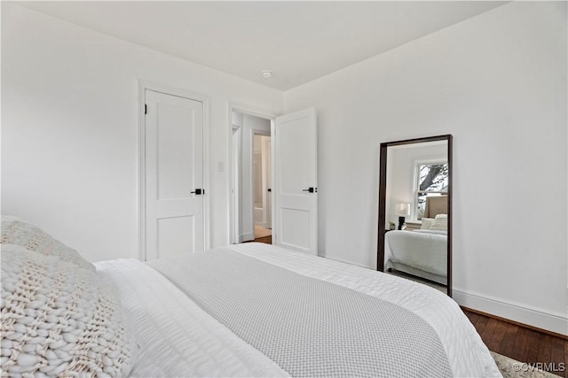 bedroom with baseboards and dark wood-style flooring