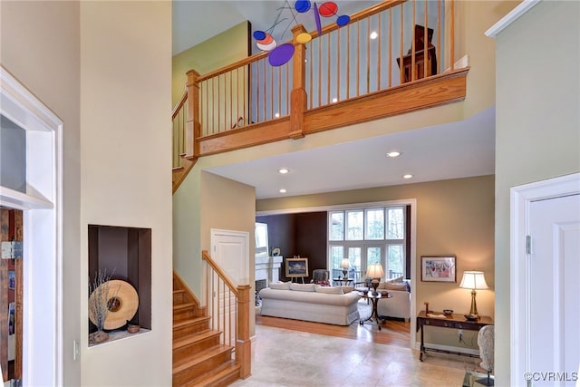 staircase with recessed lighting and a high ceiling