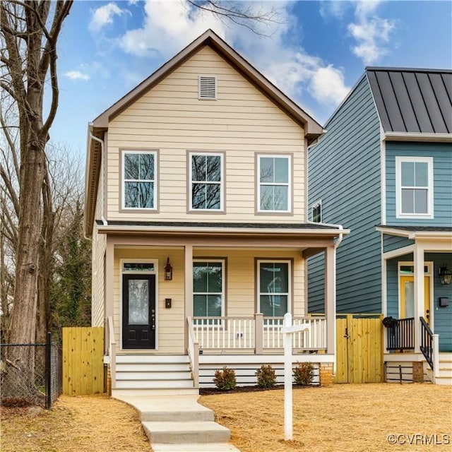 view of front facade featuring metal roof, a standing seam roof, a gate, fence, and a porch