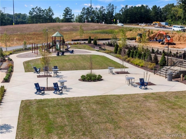 view of community with playground community, a lawn, and a patio area