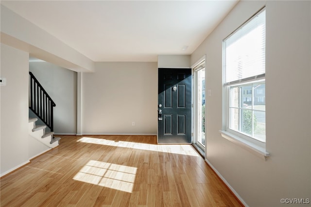 foyer featuring stairway, baseboards, and wood finished floors