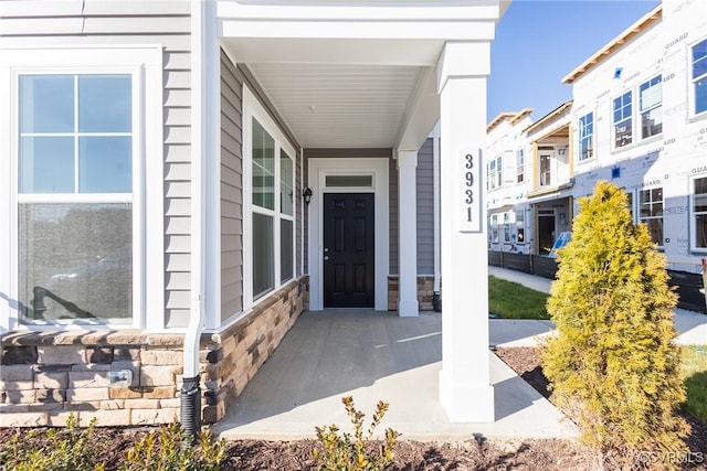 property entrance with a porch and stone siding