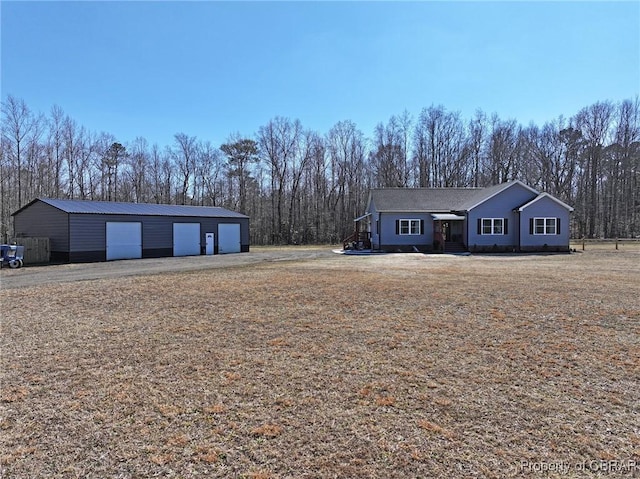 view of front of house featuring a detached garage and an outdoor structure