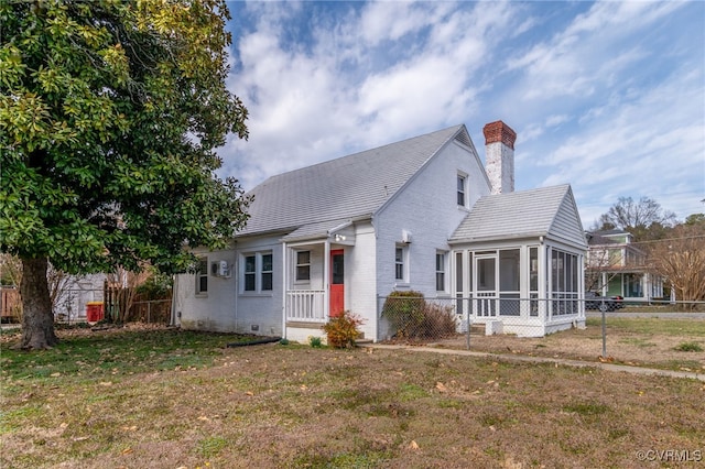 bungalow-style house featuring brick siding, a chimney, a front yard, a sunroom, and fence