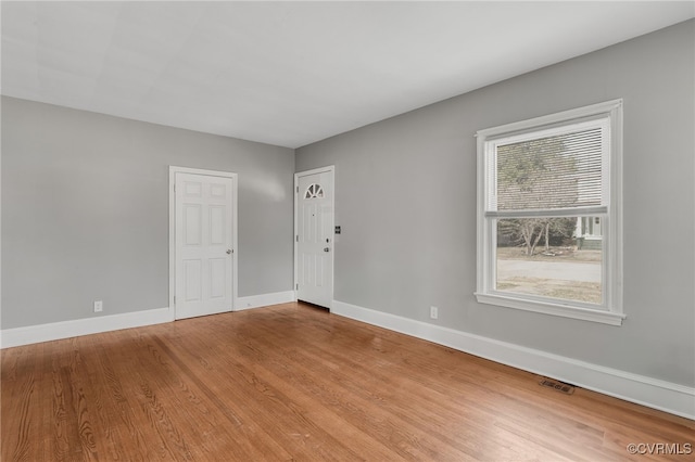 spare room with visible vents, baseboards, and wood finished floors