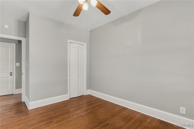 unfurnished bedroom featuring dark wood-type flooring, a closet, ceiling fan, and baseboards