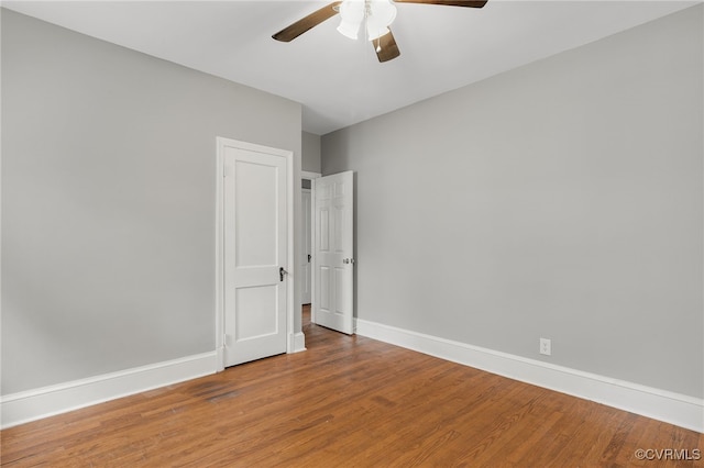 unfurnished bedroom featuring a ceiling fan, baseboards, and wood finished floors