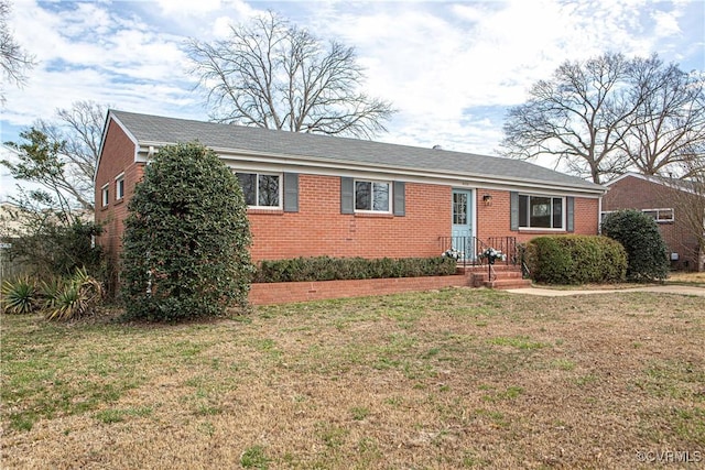 ranch-style home with a front yard and brick siding