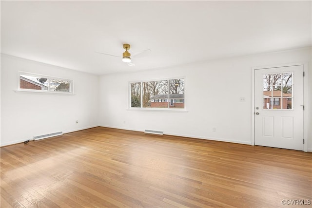 interior space featuring visible vents, baseboards, a ceiling fan, a baseboard radiator, and light wood-type flooring