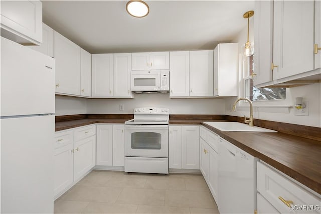 kitchen featuring white appliances, white cabinets, a sink, and hanging light fixtures