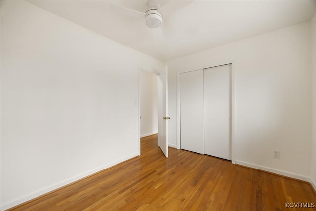 unfurnished bedroom featuring a ceiling fan, light wood-type flooring, a closet, and baseboards