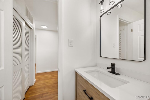 bathroom featuring visible vents, vanity, and wood finished floors