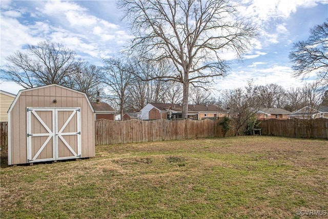 view of yard featuring a fenced backyard, a storage unit, and an outdoor structure