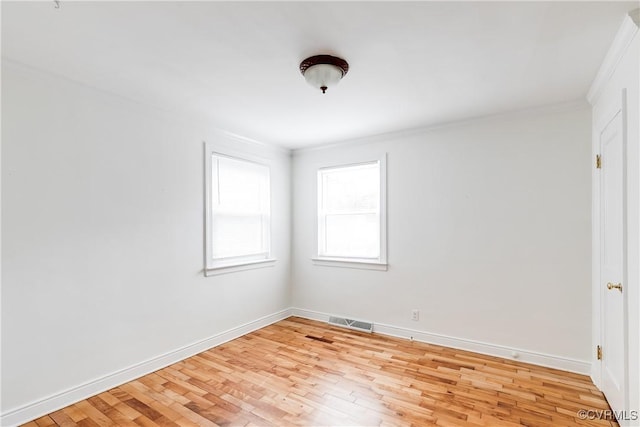 empty room with light wood-style flooring, visible vents, and baseboards