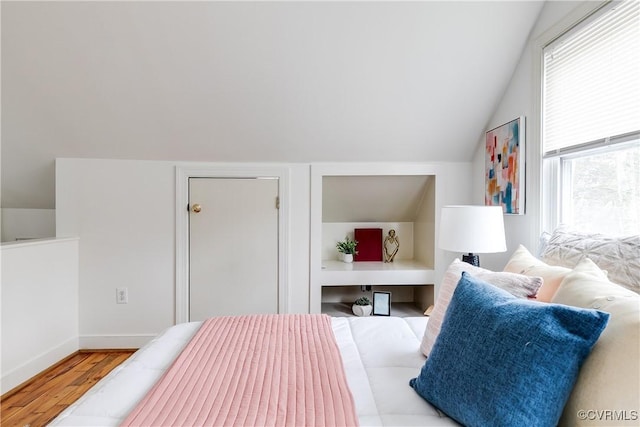 bedroom featuring lofted ceiling and wood finished floors