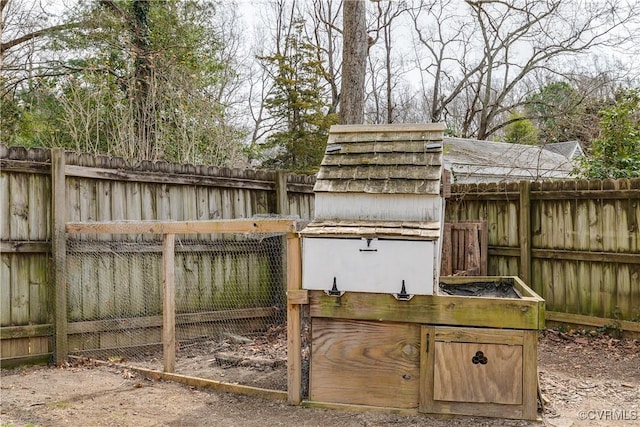 view of gate featuring a fenced backyard, exterior structure, and an outbuilding