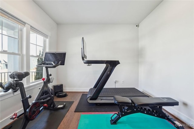 exercise area featuring baseboards and wood finished floors