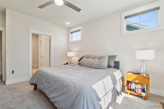 carpeted bedroom with ensuite bathroom, a ceiling fan, and baseboards