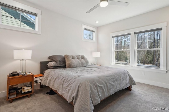 carpeted bedroom featuring baseboards and a ceiling fan