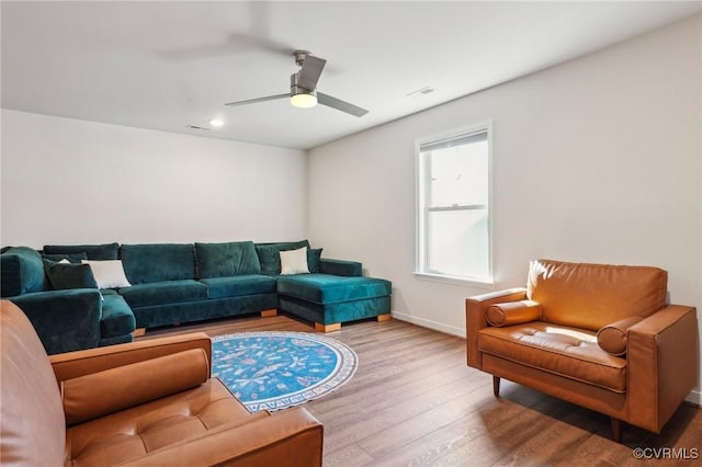 living area with visible vents, ceiling fan, baseboards, and wood finished floors