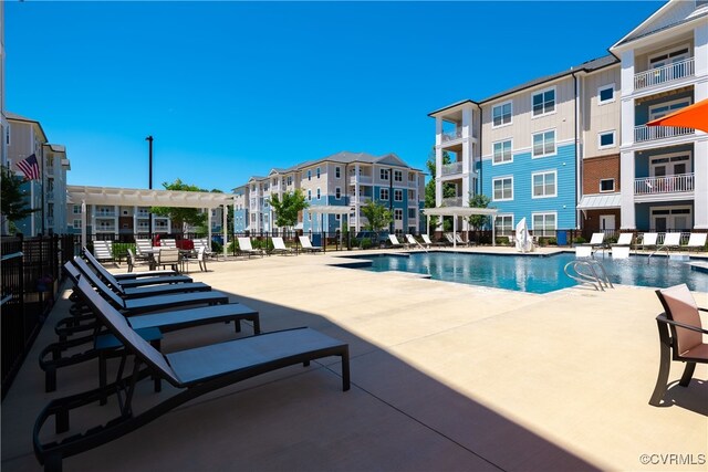 community pool with a residential view, a pergola, and a patio