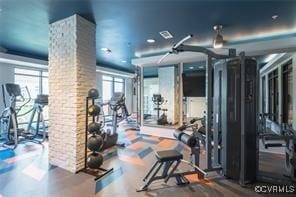 gym featuring ornate columns and wood finished floors