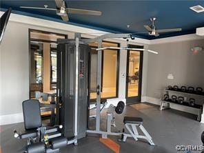 exercise room featuring visible vents, ceiling fan, and baseboards