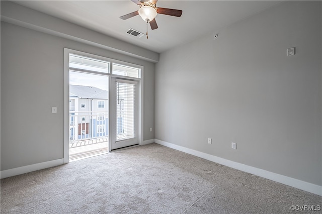 carpeted empty room with visible vents, ceiling fan, and baseboards