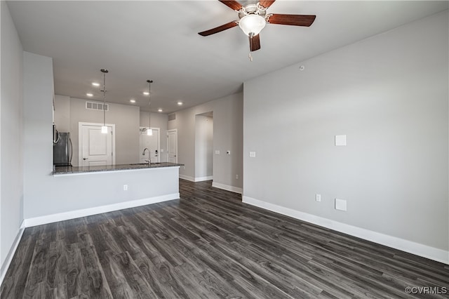 unfurnished living room with dark wood-style flooring, recessed lighting, visible vents, a sink, and baseboards