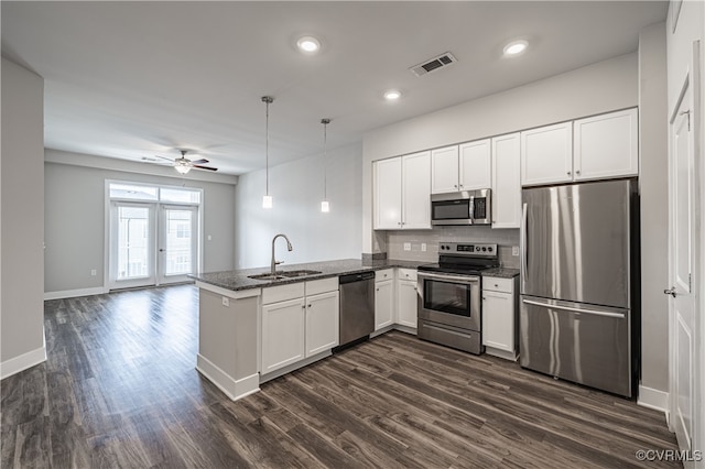 kitchen with stainless steel appliances, visible vents, white cabinets, a sink, and a peninsula